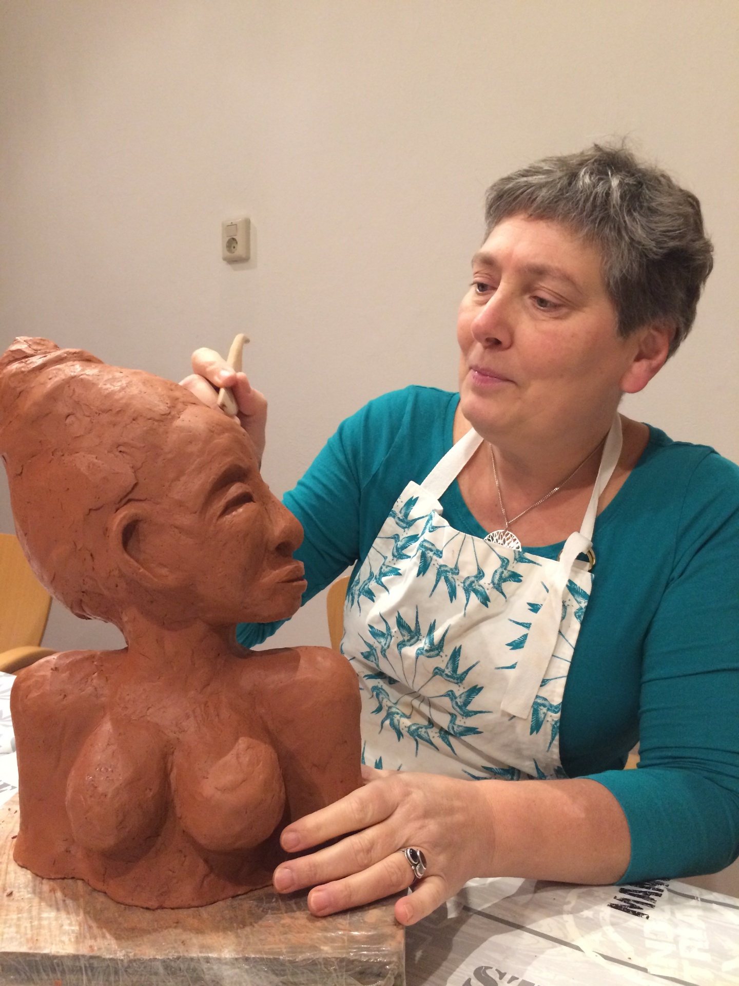 Julia aan het werk in haar atelier — kleiwerk voor een beeldurn